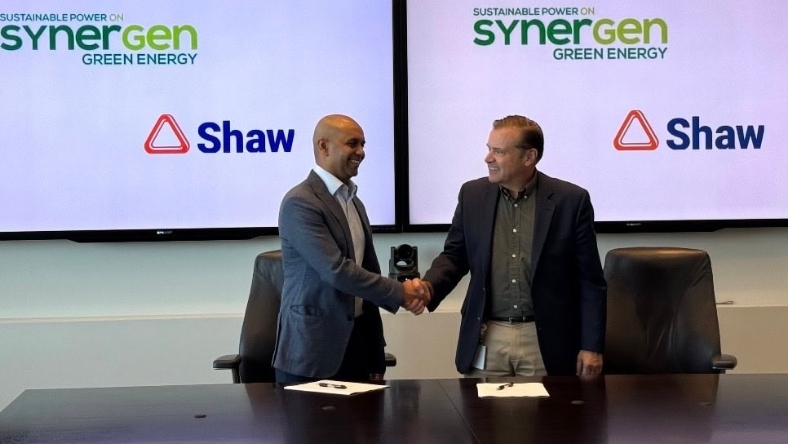 Energy executives shaking hands during a green ammonia partnership announcement